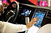 Eine junge Frau bedient das große Touch-Display in einem Tesla 3