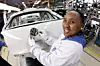 Mitarbeiterin Mandisa Jacobs mit einem VW-Emblem an einem Volkswagen Polo im südafrikanischen Werk.