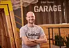 Bernhard Schambeck, Leiter der BMW Startup Garage, mit verschränkten Armen vor dem Logo.