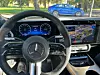 Innenansicht eines Mercedes-Benz CLA mit digitalem Cockpit. Lenkrad im Vordergrund, dahinter volldigitales Kombiinstrument und großer Touchscreen mit Navigationsanzeige.