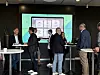 Networking-Szene auf der CMxC 2026 Corporate Mobility Conference im Hochhaus des Süddeutschen Verlags in München mit mehreren Teilnehmenden an Stehtischen, Gesprächen während der Pause, Business-Konferenz zur Unternehmensmobilität, Flottenmanagement, Elektromobilität, Mobilitätsbudget, Heimlademanager, Tankkarte, Ladekarte und Deutschland-Jobticket auf großer Präsentationswand im Hintergrund, Fachpublikum aus Fuhrpark, HR, IT, Finanzen und Einkauf im Austausch über digitale und nachhaltige Corporate Mobility