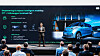 ZYT-CEO Shen Shaojie steht auf einer Bühne vor Publikum. Auf der großen Präsentationswand hinter ihm ist ein Volkswagen ID. Buzz zu sehen. Die Folie beschreibt einen lokalisierten Proof of Concept von ZYT und Volkswagen mit Lidar, Rechenplattform und ADAS-Funktionen wie Urban und Highway NOA sowie automatisiertem Parken.
