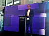 Oliver Blume steht bei der Eröffnung des CARIAD Automotive Software Campus in Berlin an einem Rednerpult. Im Hintergrund ist eine blau-violett beleuchtete Bühne mit großflächigem CARIAD-Design zu sehen.