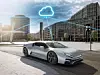Silbernes Elektro-Sportcoupé vor Glasgebäuden mit digitaler Wolken- und Ladegrafik.