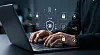 Person arbeitet an einem Laptop, darüber liegen digitale Sicherheitssymbole wie Schlösser, Dokumente, Cloud und ein Schutzschild.