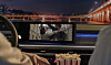 Blick in den Innenraum eines Hyundai bei Nacht. Auf dem zentralen Fahrzeugdisplay läuft ein Film, während im Vordergrund eine Popcorntüte zu sehen ist.