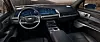 Innenraum eines Cadillac mit großflächigem Digitaldisplay, Infotainmentsystem, Lenkrad und Touchscreen in der Mittelkonsole.