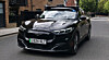 Schwarzer Ford Mustang Mach-E mit Sensoraufbau für automatisiertes Fahren auf einer Londoner Wohnstraße.
