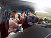 Drei Personen in einem Auto, mit blauen Markierungen über den Gesichtern und im Innenraum.