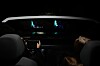 Blick aus dem Fahrzeuginnenraum bei Nacht auf ein digitales Cockpit. Auf der Windschutzscheibe werden Fahrinformationen und eine virtuelle Spurführung als 3D-AR-Head-up-Display eingeblendet.