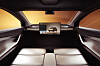 Futuristischer Fahrzeuginnenraum mit zwei Sitzen, großem Display und warm beleuchteten Fensterflächen.