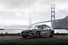 Silberner Mercedes-Benz vor der Golden Gate Bridge an einer Uferstraße in San Francisco.