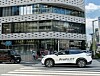 Weißer Nissan mit ProPILOT-Schriftzug fährt vor einem Nissan-Gebäude in Tokio über eine Kreuzung.