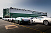 Mehrere Bentley-Fahrzeuge stehen in einer Reihe vor einem großen Autotransportschiff der Reederei Wallenius Marine, das an einem Hafen liegt.