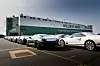 Mehrere Bentley-Fahrzeuge stehen in einer Reihe vor einem großen Autotransportschiff der Reederei Wallenius Marine, das an einem Hafen liegt.