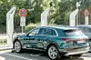 Ein grüner Audi E-Tron lädt an einer Ladestation.