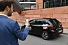 Ein Mann mietet per App ein Carsharing-Fahrzeug von Miles am Straßenrand
