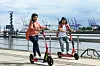 Zwei Jugendliche fahren auf E-Scootern durch Hamburg.