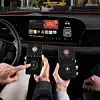 Zwei Personen sitzen in einem Audi-Fahrzeug und bedienen über ihre Smartphones das In-Car-Gaming-System AirConsole. Auf dem zentralen Infotainmentdisplay ist das Spiel „UNO Car Party!“ sichtbar. Die Smartphones zeigen virtuelle Gamecontroller mit Bedienfeldern an. Das Fahrzeug befindet sich im Stand. Das Audi-Logo ist am Lenkrad erkennbar, der Innenraum modern und digital gestaltet.