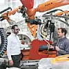 Zwei Experten vor einer Produktionsanlage bei Audi in Neckarsulm