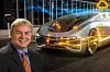 Porträt von Thomas Raste, Principal Expert für Vehicle Dynamics bei Continental, vor dem Hintergrund eines futuristischen Fahrzeugs mit digital eingeblendeten Vernetzungs- und Steuerungselementen – symbolisierend softwaredefinierte Fahrzeugarchitekturen und intelligente Bewegungssteuerung.