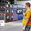 Ein Mitarbeiter von Skoda steht in der Logisikhalle vor Paletten und fotografiert diese mit einem Tablet.