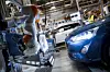 Ein Roboter in der Fertigung von Ford neben einem Ford Focus.