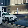 Ein Porsche Taycan an einer Straße mit mehreren Ionity-Ladesäulen.