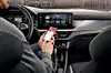 Ein Mann bedient sein Smartphone über die Skoda Connect-App am Steuer