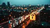 The image depicts a glowing holographic padlock overlaying a bustling nighttime road in Bangkok, symbolizing cyber security measures.