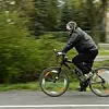 Ein Mann mit Mundschutz fährt auf einem Fahrrad