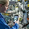Eine Mitarbeiterin von BMW scannt einen QR-Code in der Produktion.