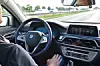 Ein Mann sitzt am Steuer eines BMW und lässt das autonome Fahren die Steuerung übernehmen, ohne dass er die Hände am Lenkrad hat.