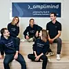 Mitarbeiter:innen von amplimind sitzen auf Stufen