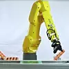 Ein Roboterarm bestückt Leiterplatten in der Industrie