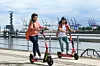 Zwei junge Menschen fahren auf den Hive-Scootern durch Hamburg