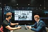 Ein Verkäufer und ein Kunde sitzen im Mercedes-Autohaus an einem Tisch und blicken auf einen Bildschirm.