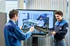 Zwei Mitarbeiter von BMW drehen mit dem Tablet ein Schulungsvideo für Augmented Reality.