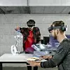 Zwei Entwickler mit Head-Mounted-Displays erarbeiten eine Konzept mit Hilfe einer Visualisierung auf dem Tisch.